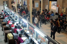 Hành khách làm thủ tục mua vé tàu tại Ga Hà Nội. (Ảnh: Quang Quyết/TTXVN)