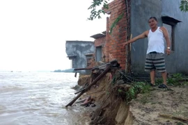 Một ngôi nhà chênh vênh sắp bị lũ 'nuốt chửng'. (Ảnh: Phước Ngọc/TTXVN)