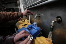 Người dân Palestine lấy nước uống tại trại tị nạn ở Rafah, miền nam Dải Gaza. (Nguồn: AFP/TTXVN)