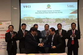 Đại diện tỉnh Bình Phước ký kết Biên bản Ghi nhớ với Hiệp Hội Thương mại Việt Nam tại Singapore. (Ảnh: Mỹ Bình/Vietnam+)