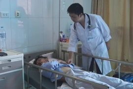 Bác sỹ Bệnh viện Đa khoa tỉnh Bắc Ninh thăm khám cho nạn nhân Nguyễn Thành Đạt. (Ảnh: Diệp Trương/TTXVN)