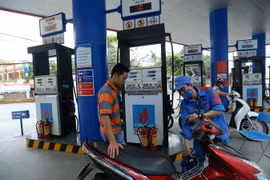 Khách hàng mua xăng tại Cửa hàng xăng dầu của PV OIL Hà Nội. (Ảnh: Huy Hùng/TTXVN)