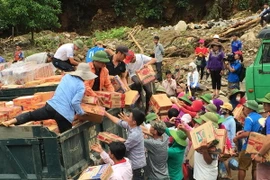 Tiếp nhận hàng cứu trợ để chuyển đến người dân vùng lũ tại xã Nặm Păm, Sơn La. (Ảnh: Hữu Quyết/TTXVN)