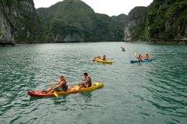 Du khách bơi thuyền Kayak trên Vịnh Hạ Long. (Ảnh: Tiến Dũng/TTXVN)