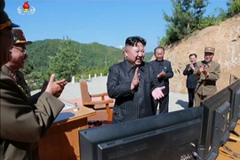 Nhà lãnh đạo Triều Tiên Tên Kim Jong-un (giữa) chỉ đạo vụ phóng thử tên lửa đạn đạo liên lục địa Hwasong-14 tại một địa điểm bí mật ở Triều Tiên. (Nguồn: YONHAP/TTXVN)