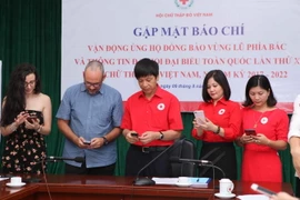 Các đại biểu nhắn tin ủng tại buổi lễ phát động. (Ảnh: Quý Trung/TTXVN)