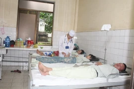 Thăm khám cho bệnh nhân sốt xuất huyết tại Bình Dương. (Ảnh: Huyền Trang/TTXVN)