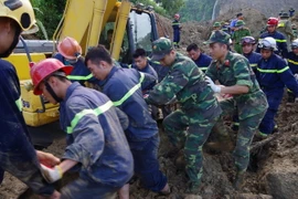 Lực lượng cứu hộ huy động máy xúc chuyên dụng vào xóm Khanh, xã Phú Cường, huyện Tân Lạc để tiếp tục tìm kiếm thi thể nạn nhân còn lại đang bị vùi lấp. (Ảnh: Vũ Hà/TTXVN)