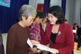 Phó Chủ tịch nước Đặng Thị Ngọc Thịnh tặng quà các gia đình chính sách và hộ nghèo. (Ảnh: Thanh Bình/TTXVN)