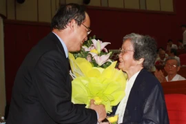 Phó Thủ tướng Nguyễn Thiện Nhân tặng hoa cụ bà Hoàng Kim Anh, vợ cố Giáo sư Tạ Quang Bửu. (Ảnh: Phạm Mai/Vietnam+).