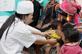 Bác sỹ khám bệnh cho trẻ em khó khăn của đồng bào dân tộc thiểu số. (Ảnh: Thanh Tùng/TTXVN)