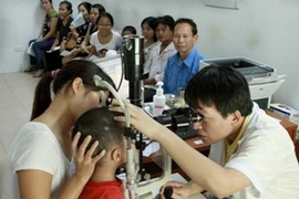 Bác sỹ khám cho bệnh nhân nhi đau mắt đỏ tại Hà Nội. (Ảnh: Dương Ngọc/TTXVN)