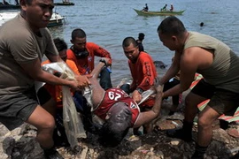 Lực lượng bảo vệ bờ biển Philippines chuyển thi thể một ngư dân vừa tìm thấy. (Ảnh: AFP/TTXVN)