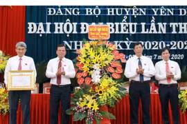 Bí thư Tỉnh ủy Bắc Giang Bùi Văn Hải (thứ 2 từ phải sang) tặng hoa chúc mừng và trao Bằng khen của Ban thường vụ Tỉnh ủy cho Đảng bộ huyện Yên Dũng. (Ảnh: Đồng Thúy/TTXVN)