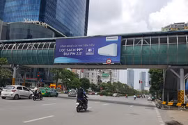 Bảng quảng cáo vi phạm tại cầu vượt dành cho người đi bộ đường Nguyễn Chí Thanh (quận Đống Đa). (Ảnh: Đinh Thuận/TTXVN)