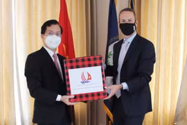 Đại sứ Hà Kim Ngọc chuyển quà cho Giám đốc điều hành của DFC Adam Boehler. (Ảnh: Phạm Ngọc Ánh/TTXVN)