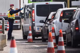 Cảnh sát Hungary kiểm tra thân nhiệt của tài xế tại khu vực cửa khẩu giữa Hungary-Áo, nhằm ngăn chặn sự lây lan của dịch COVID-19. (Ảnh: AFP/TTXVN)