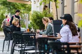 Người dân tại một quán càphê ở Berlin, Đức, ngày 26/5. (Ảnh: THX/TTXVN)