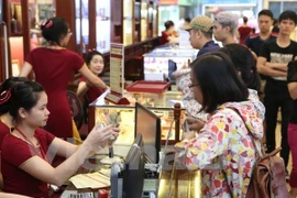 Khách hàng giao dịch vàng miếng. (Ảnh: Đức Duy/Vietnam+)