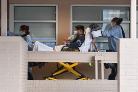 Nhân viên y tế chuyển nạn nhân nhiễm COVID-19 tới bệnh viện ở Brooklyn, New York, Mỹ. (Ảnh: AFP/TTXVN)