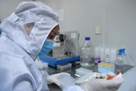 Nghiên cứu nhằm chế tạo dụng cụ phát hiện nhanh virus SARS-CoV-2 gây dịch COVID-19 tại phòng thí nghiệm của Công ty công nghệ sinh học ở Lạc Dương, tỉnh Hà Nam, Trung Quốc. (Ảnh: THX/TTXVN)