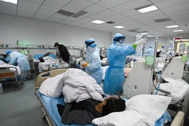 Nhân viên y tế điều trị cho bệnh nhân nhiễm COVID-19 tại Trung Quốc. (Ảnh: THX/TTXVN)