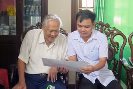 Anh hùng lực lượng vũ trang nhân dân Hồ Đắc Thạnh (bên trái) kể chuyện tham gia lễ duyệt binh năm 1960 cho phóng viên nghe. (Ảnh: Xuân Triệu/TTXVN)