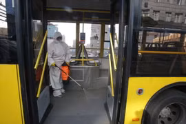 Nhân viên phun thuốc khử trùng trên xe buýt ở Kiev, Ukraine. (Ảnh: THX/TTXVN)