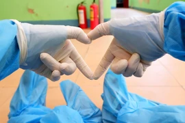 Sự lạc quan, yêu đời giúp các thanh niên tình nguyện không thấy mệt mỏi khi làm việc tại khu cách ly. (Ảnh: TTXVN phát)