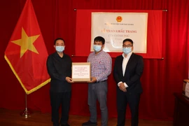 Đại sứ đặc mệnh toàn quyền nước CHXHCN Việt Nam tại Canada Phạm Cao Phong trao khẩu trang cho đại diện bà con cộng đồng người Việt tại thành phố Montreal. (Ảnh: Quang Thịnh/TTXVN)