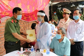 Thiếu tướng Lê Tấn Tới chia buồn và trao tiền hỗ trợ đến gia đình đại úy Lê Thanh Hải. (Ảnh: Chí Tưởng/TTXVN)