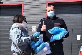Đại diện người Việt Nam tỉnh Odessa, Ukraine tặng khẩu trang cho cơ quan phòng cháy chữa cháy quận Ovidiopol. (Ảnh: TTXVN phát)