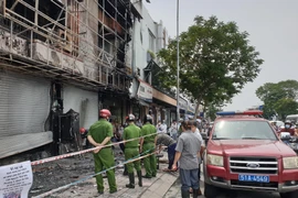 Công an khám nghiệm hiện trường vụ cháy. (Ảnh: Thành Chung/TTXVN)