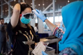 Nhiên viên y tế kiểm tra thân nhiệt tại Malaysia. (Nguồn: asiatimes)	