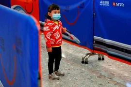 Bé gái đeo khẩu trang phòng nguy cơ dính virus corona. (Nguồn: Reuters)