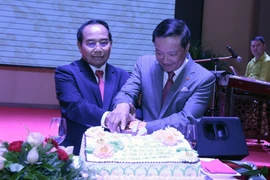 Đại sứ Việt Nam tại Lào Nguyễn Bá Hùng (phải) và Phó Thủ tướng Lào Bounthong Chithmany đang cắt bánh mừng 75 năm quốc khánh Việt Nam tại Lào. (Ảnh: Phạm Kiên/TTXVN)