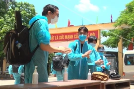 Các công dân tiến hành sát khuẩn khi vừa đến khu cách ly của Trung đoàn Bộ binh 126. (Ảnh: Đinh Tuấn/TTXVN)