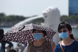 Người dân đeo khẩu trang để phòng tránh lây nhiễm virus corona tại Singapore. (Ảnh: AFP/TTXVN)