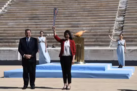 Cựu vận động viên bơi lội Nhật Bản Imoto Naoko giơ cao ngọn đuốc Olympic. (Ảnh: AFP/TTXVN)