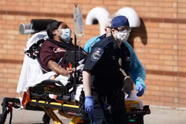Nhân viên y tế chuyển bệnh nhân mắc COVID-19 tới bệnh viện ở Brooklyn, New York, Mỹ. (Ảnh: AFP/TTXVN)