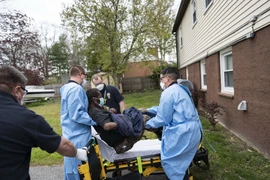 Nhân viên y tế hỗ trợ chuyển bệnh nhân COVID-19 tại Glen Burnie, Maryland (Mỹ) ngày 25/4. (Ảnh: AFP/TTXVN)