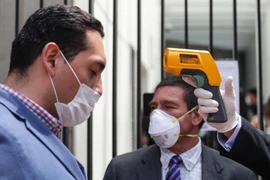 Kiểm tra thân nhiệt nhằm ngăn dịch COVID-19 lây lan tại Mexico City. (Ảnh: THX/TTXVN)