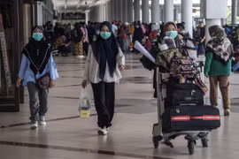 Hành khách tại sân bay Juanda ở Sidoarjo, Indonesia ngày 3/3/2020. *Ảnh: AFP/TTXVN)