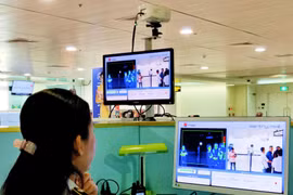 Nhân viên sân bay Tân Sơn Nhất kiểm tra màn hình hiển thị máy quét thân nhiệt đối với hành khách quốc tế đến Việt Nam. (Ảnh: Đinh Hằng/TTXVN)