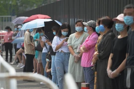 Người dân xếp hàng chờ xét nghiệm COVID-19 tại Bắc Kinh, Trung Quốc. (Ảnh: AFP/TTXVN)