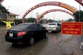 Người di chuyển về tỉnh Thái Bình được yêu cầu đo thân nhiệt và khai báo y tế tại các chốt kiểm dịch. (Ảnh: Thế Duyệt/TTXVN)