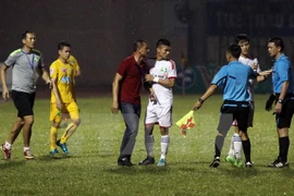 HLV Ngô Quang Trường phản ứng trọng tài vì quyết định thổi phạt penalty. (Ảnh: Thanh Tùng/TTXVN)