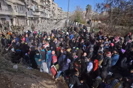 Những người dân Syria, từng phải sơ tán để tránh các cuộc giao tranh, tập trung tại điểm kiểm soát ở Maysaloun - khu vực lân cận với Aleppo ngày 8/12. (Nguồn: AFP/TTXVN)