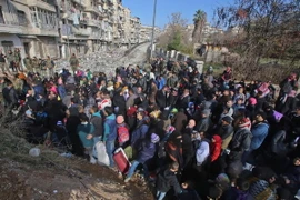 Những người dân Syria, từng phải sơ tán để tránh các cuộc giao tranh, tập trung tại điểm kiểm soát ở Maysaloun - khu vực lân cận với Aleppo ngày 8/12. (Nguồn: AFP/TTXVN)