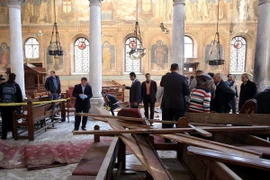 Nhân viên an ninh và người dân điều tra tại hiện trường nhà thờ Công giáo Coptic ở quận Abbasiya sau vụ đánh bom. (Nguồn: EPA/TTXVN)